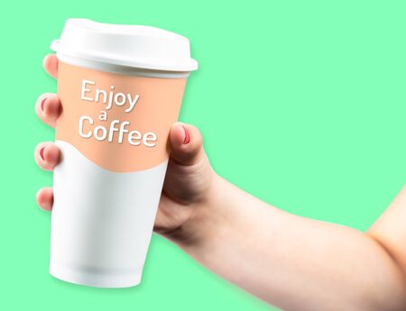 Female Hand Holding Takeaway coffee cup on green background, Enjoy Coffee Logoの写真素材