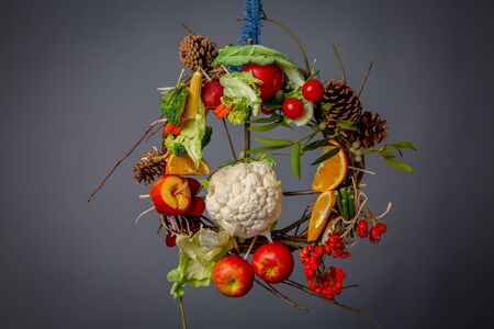 Fruit and Vegetable Christmas themed Ornamental Wreath on a Grey Backgroundの写真素材