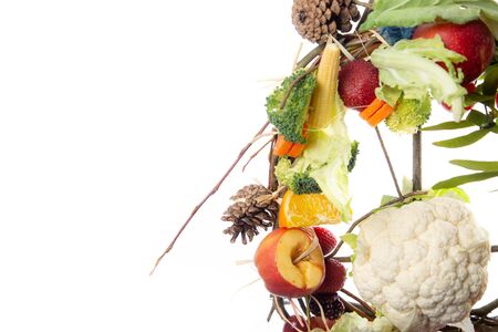 Fruit and Vegetable Christmas themed Ornamental Wreath on a White Background with copy spaceの写真素材