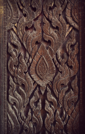 Thai style pattern carved on wood door temple, retro vintage styleの写真素材