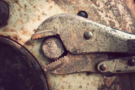 Rusty locking pliers and bolt on wheel tractors, retro and vintage styleの写真素材