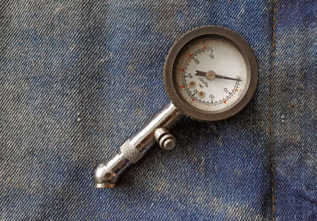 Tire pressure gauge placed on denim fabricの写真素材