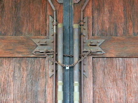 Old wooden door locked with chain and padlock, closeup of photo