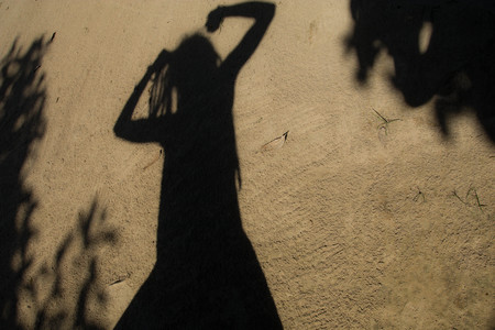 Shadows of people in various  stance on soil background.の写真素材