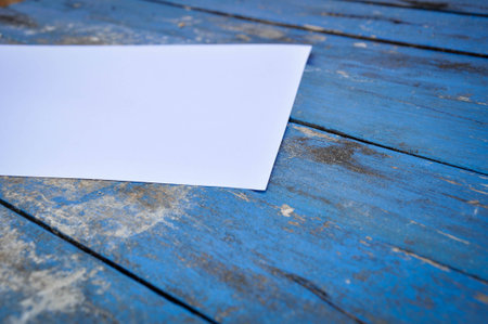 White paper on a wooden table in blue.の写真素材