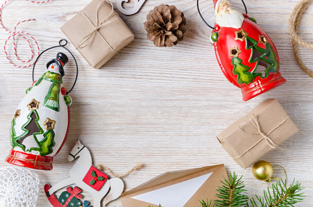 Christmas background. Holiday decorations: gifts, candle holders, snowman, Santa Claus on a wooden light table. Top view.の写真素材