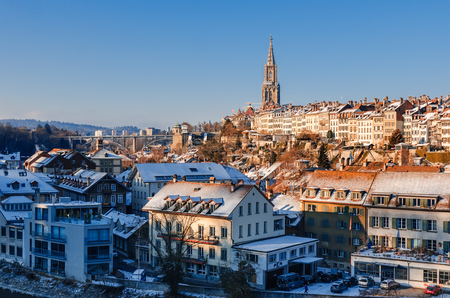 Panorama of the snow-covered roofs of Bern's old town and Steeple of Berne Cathedral. Ancient cities...