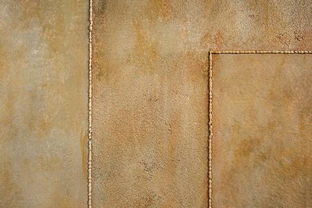 Textured rusty metal background. Decorative plaster. Interior wall decoration. Imitation of an old wall close-up.の写真素材