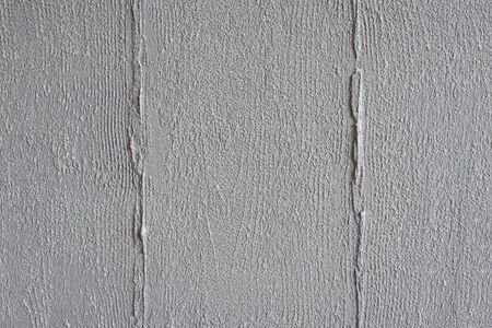 Textured gray background. Decorative concrete plaster imitates the imprint of a wooden board. Exterior decoration of the facade close-up.の写真素材