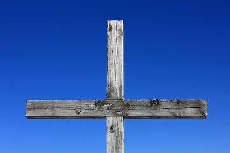 Part of a weathered wood cross on blue sky の写真素材