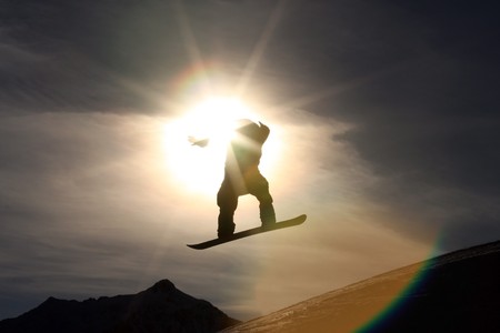 Snowboarder jumping high in the air in front of a dark skyの写真素材