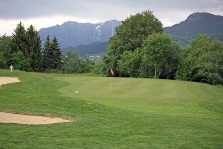 Golf green in front of a mountain sceneryの写真素材