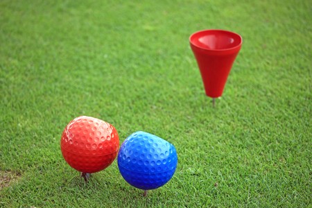 Close view of a red and a blue ball on a tee with a red tee cupの写真素材