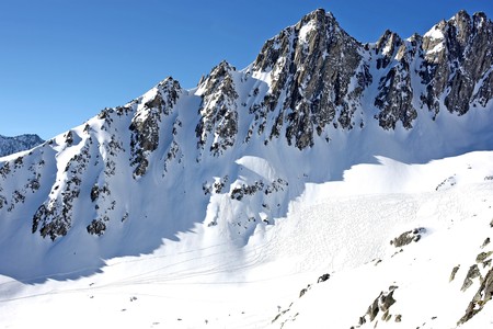 Mountains covered with snow with ski tracks の写真素材