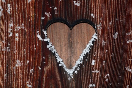 Close view of a wooden background with a heart cut outの写真素材