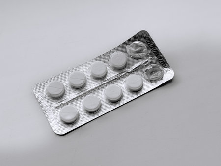 pillssealed tablets with professional pharmaceutical packaging, blister pack with neatly arranged pills on neutral background, sterile pharmaceutical dosage containers with uniform tablets arrangedの写真素材