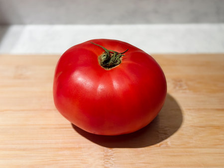tomatocloseup of fresh ripe produce, photograph emphasizing natural texture and bright color of ripe tomato, detailed shot highlighting vibrant appearance and organic quality of freshly picked tomatoの写真素材