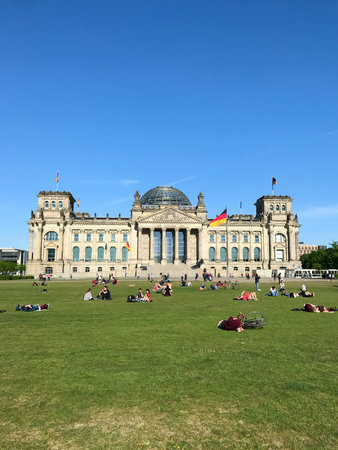 Berlin, Germany, May 6, 2018, Bundestag, people relaxing at historic berlin parliament, sunlit city park with visitors enjoying leisure activitiesのeditorial素材