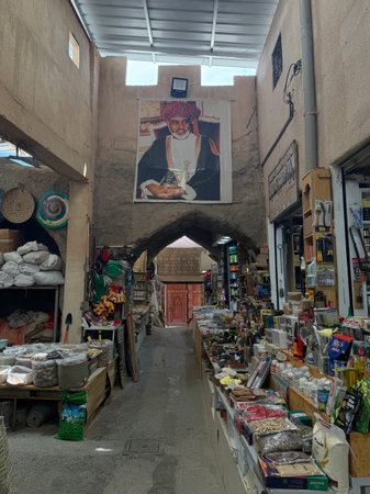 Spice and grocery stalls inside traditional covered souk corridor in Nizwa Omanのeditorial素材