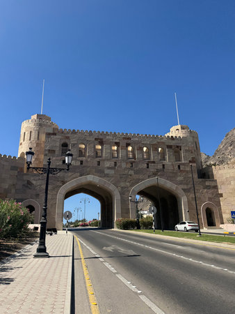 Muscat Gate Museum. Stone city gate with arches over highway in Muscat, Oman on sunny dayのeditorial素材