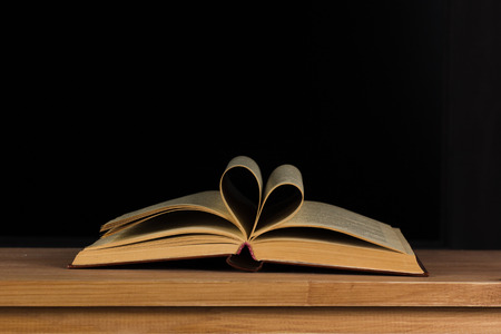 open book on the table in the form of heartの写真素材