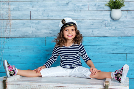 child in striped vest sits on a splitsの写真素材