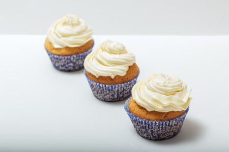 Three cupcakes with yellow curd cream, closeupの写真素材