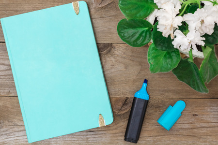 notepad and a flower on aged boards, flat layの写真素材