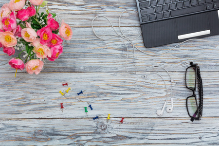 workplace: laptop, glasses and flowers, flat lay