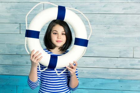 little girl holding a lifebuoy and laughing, looking at camera