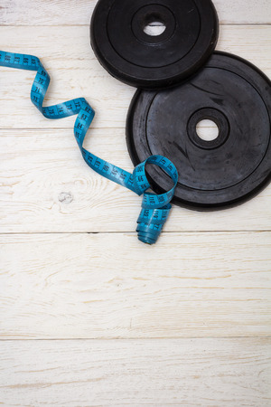 dumbbell and measuring tape on white boards,の写真素材