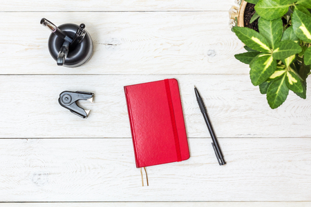 red notepad and stationery on white boards, top viewの写真素材