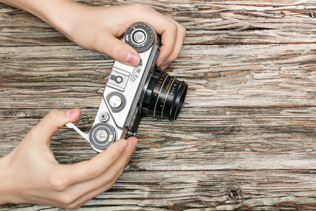 woman's hands holding a retro camera, flat layの写真素材