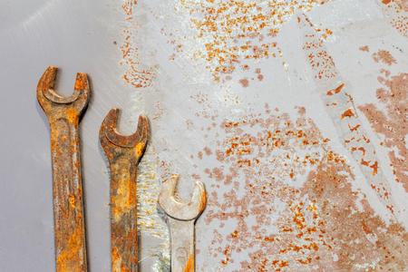 three wrenches on rusty metal, flat lay