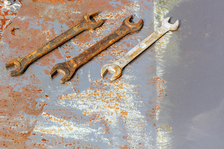three wrenches on rusty metal, flat lay