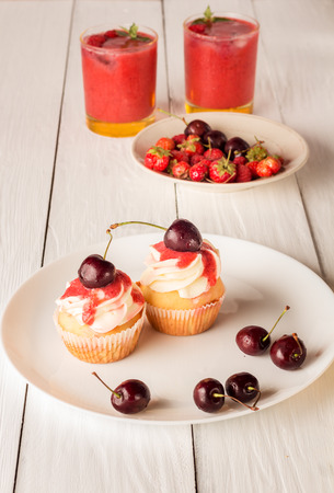 Cupcakes with cherries and berry smoothies. Closeupの写真素材