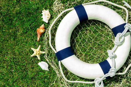 White lifebuoy on green lawn, space for textの写真素材