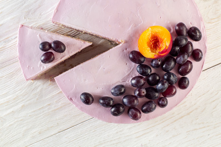 Cut piece fruit cheesecake decorated with grapes. Top viewの写真素材