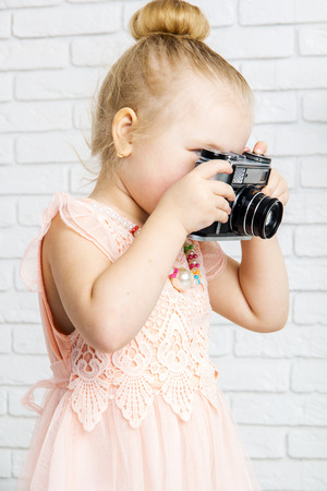 Little girl with retro camera in hand, closeupの写真素材