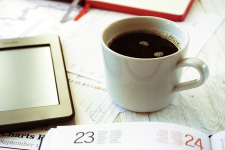 Workplace in office, coffee and ebook closeup