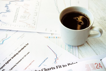 Workplace in office, coffee and graphs closeupの写真素材