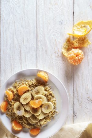 oatmeal with tangerine and banana for breakfastの写真素材