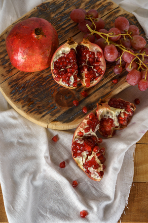 Still life of autumn fruits, pomegranates, grapes. Top view.の写真素材
