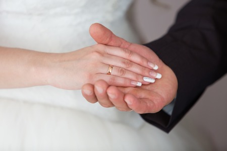 Gold wedding rings on the hands of the newlywedsの写真素材
