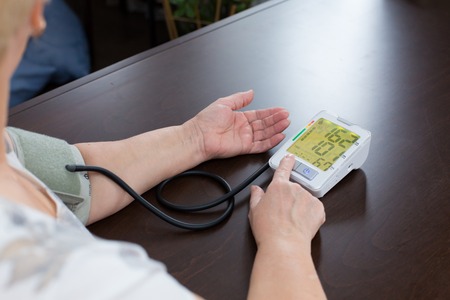 the woman measures to herself a blood pressureの写真素材