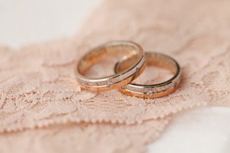two wedding rings on pink laceの写真素材