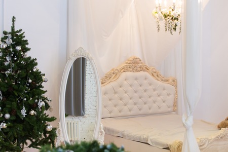 classical interior with big white a mirror and a bedの写真素材