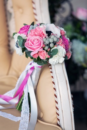 gentle pink bridal bouquet on a beige sofaの写真素材