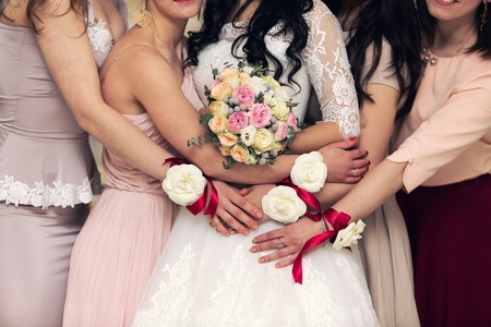 bridesmaids with bracelets in the form of flowers embrace brides