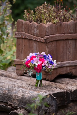 bright bridal bouquet of red and violet color on wooden boardsの写真素材